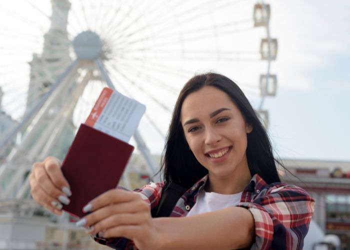 Young woman holding an EU passport and boarding pass